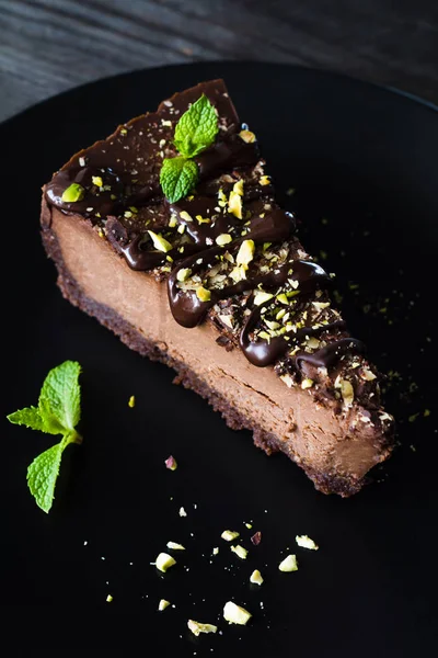 Κομμάτι από το σκοτεινό κέικ σοκολάτας κρέμα διακοσμημένο με φύλλα μέντας — Φωτογραφία Αρχείου