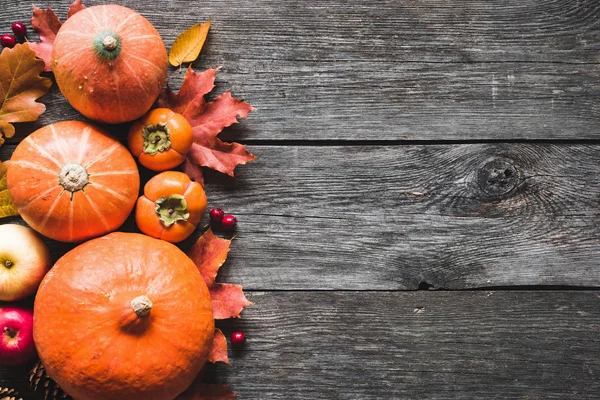 Fondo de Acción de Gracias con calabazas, manzanas y hojas caídas sobre mesa de madera — Foto de Stock