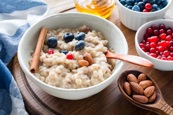 Oatmeal porridge with berries, cinnamon and honey. Balanced meal — Stock Photo, Image