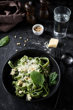 Vejetaryen yeşil makarna ıspanak, çam fıstığı ve rendelenmiş peynir ile