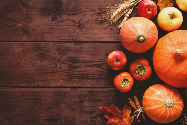 Fondo de Acción de Gracias con calabazas, manzanas y hojas caídas sobre mesa de madera — Foto de Stock