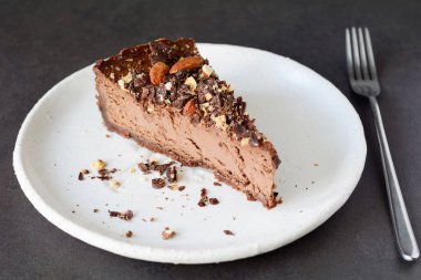 Çikolatalı cheesecake dilim beyaz plaka üzerinde