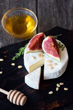 İncir ve ballı kesme tahtası üzerinde Camembert veya brie peyniri