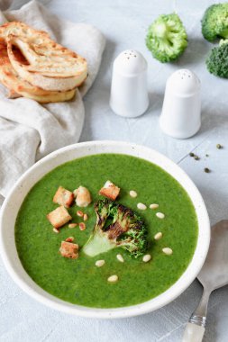 Vejetaryen brokoli krem çorba, kruton ve kavrulmuş dolmalık fıstık beyaz kase