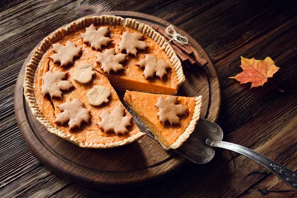 Tarte à la citrouille maison avec tranche découpée sur fond en bois pour Thanksgiving table à manger — Photo