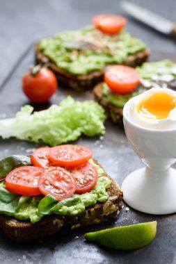 Avokado, ıspanak, kiraz domates ve haşlanmış yumurta tost. Sağlıklı beslenme, sağlıklı kahvaltı konsepti