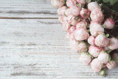 Kopya alanı metin için vintage ahşap zemin üzerine pembe çalı gül buketi