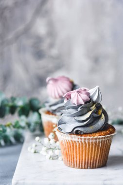 Mermer zemin üzerine krema ile pastel renk cupcakes