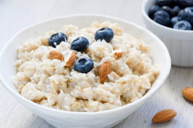 Yulaf ezmesi Hindistan cevizi püresi ile yaban mersini ve badem beyaz kase