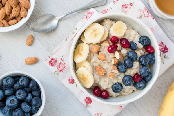 Vista dall'alto di colazione sana con porridge di avena, bacche, frutta e tè verde — Foto Stock