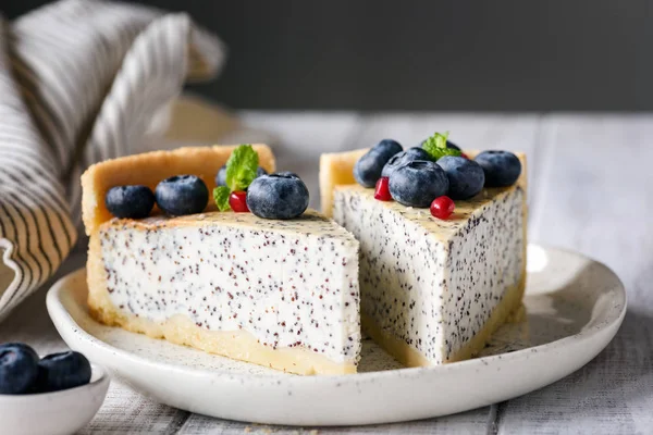 Two slices of cheesecake with poppy and blueberries — Stock Photo, Image