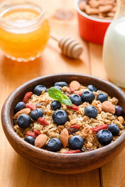 Müsli mit Trockenfrüchten, Nüssen und frischen Blaubeeren in Holzschale — Stockfoto