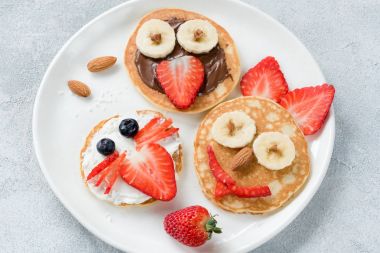 Komik renkli kahvaltı hayvan yüzleri ile çocuklar için krep.