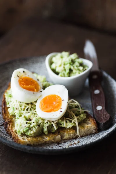 Purè di avocado, uova e formaggio sul pane tostato — Foto Stock