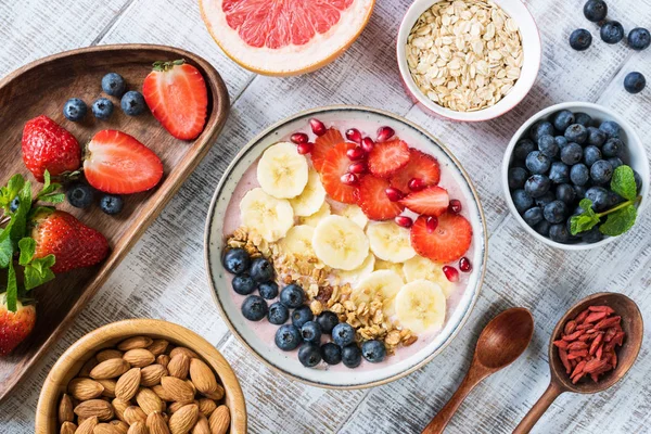 Tazón de batido con plátano, fresa, arándano, granola y granada — Foto de Stock