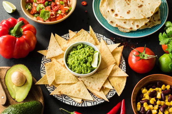 Mexican food Guacamole Nachos Tortilla chips salsa and beans — Stock Photo, Image