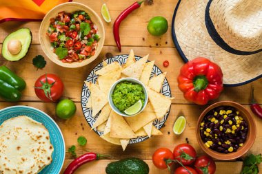Ahşap masa üzerinde geleneksel Meksika yemeği. Tortilla cips, guacamole, cips, fasulye ve salsa