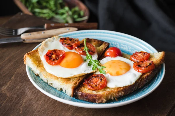 Тост на завтрак с яйцом, ругулой и жареным помидором, вид крупным планом — стоковое фото