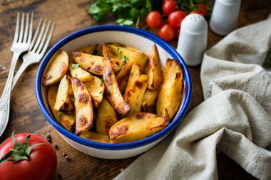 Patates dilimleri veya eski rustik masada maydanoz ile süslenmiş patates