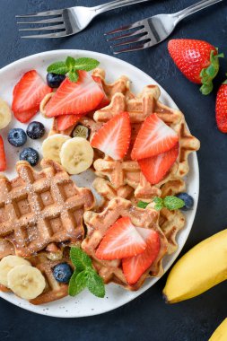 Çilek, yaban mersini ve muz ile ev yapımı waffle hizmet