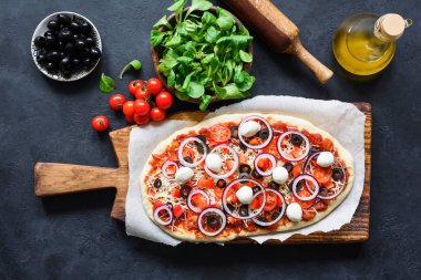 Ev yapımı pizza hazırlık. Koyu arka plan üzerinde pizza malzemeleri