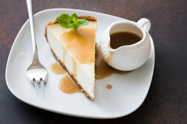 Cheesecake med kolasås på vit platta — Stockfoto