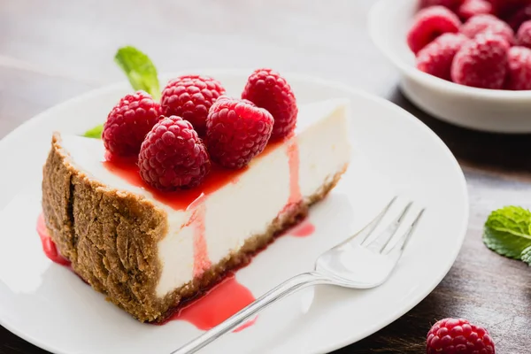 Cheesecake with raspberries and berry sauce on white plate — Stock Photo, Image
