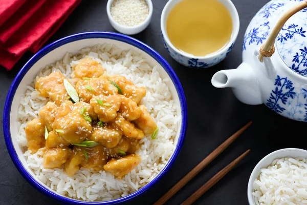 Asiatisk sesam- eller teriyaki kyckling med ris i skål, grönt te och ätpinnar — Stockfoto