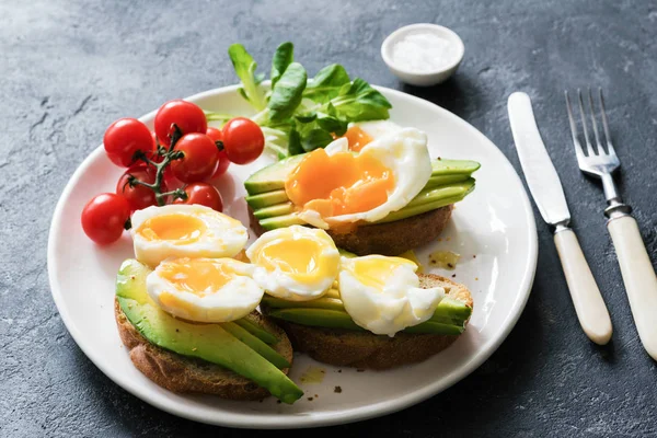 Healthy breakfast or lunch. Poached egg with avocado on whole grain toast — Stock Photo, Image