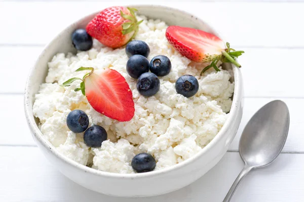 Цворог, фермерский сыр, творог или творог в белой миске со свежими летними ягодами — стоковое фото