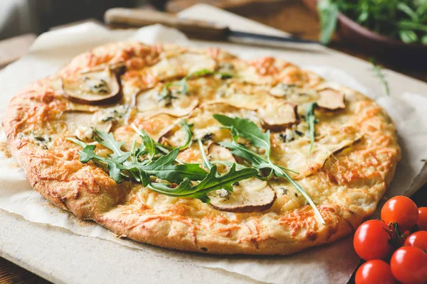 Домашняя пицца из четырех сыров с грушей и свежей рукколой — стоковое фото