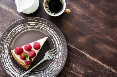 Üstten Görünüm peynirli kek ahududu, fincan kahve ve ahşap üzerine krema ile