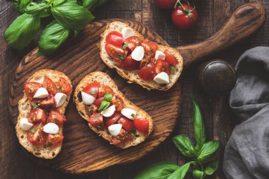 İtalyan bruschetta antipasti domates, mozzarella peyniri ve fesleğen ahşap tahta üzerinde