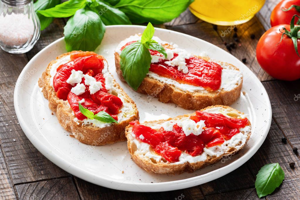 Italian antipasti bruschetta with roasted pepper, olive oil and goat cheese or feta cheese