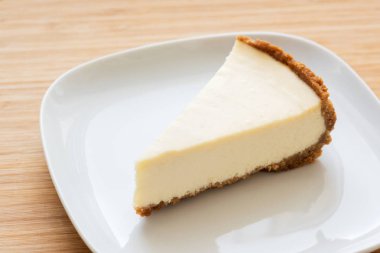 Dilim beyaz plaka üzerinde düz klasik cheesecake