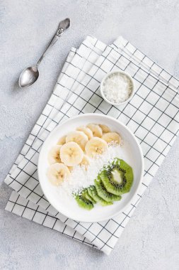 Paleo yogurt bowl with banana, kiwi and coconut flakes clipart