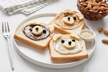 Çocuklar kahvaltı yemek ekmek fındık ezmesi ve muz ile