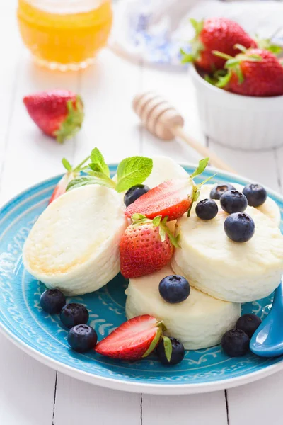 Mini cheesecake with berry fruits on a blue plate — Stock Photo, Image