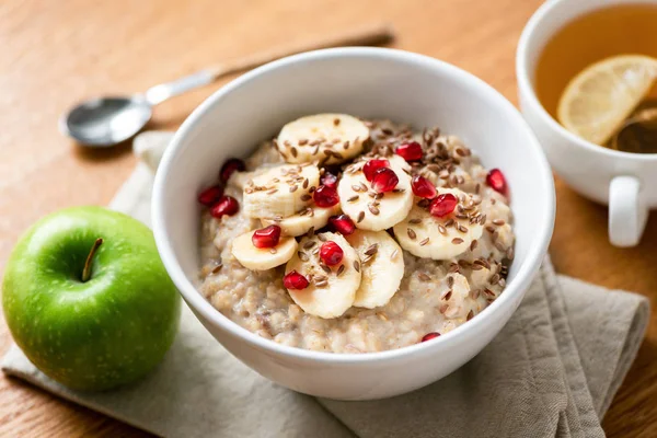 Oatmeal porridge bowl with fruit and seeds — Stock Photo, Image