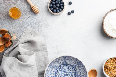 Boş tabakla kahvaltı masası, yoğurt, granola ve böğürtlen.