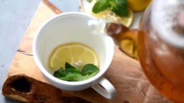 Fincana limonlu nane çayı dökülüyor. Çay demle. Sıcak bitki çayı.