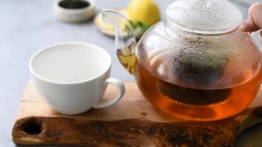 Bardağa çay dolduruyorum. Cam çaydanlıkta demlenmiş siyah çay. Sıcak Çin çayı.