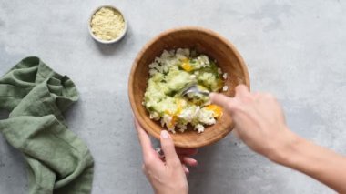 Yemek pişirme süreci. Kabak hazırlamak hamuru kaseye koyar. Kadın şef rendelenmiş kabak, bitki ve keçi peyniri karışımına tavuk yumurtası ekliyor.