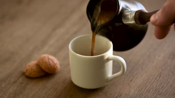 把黑咖啡倒入杯子里 用土耳其咖啡机煮浓缩咖啡 — 图库视频影像