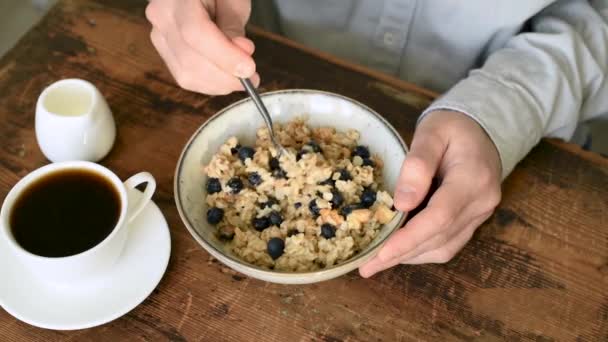 吃带有蓝莓的燕麦粥作为健康早餐的人 — 图库视频影像