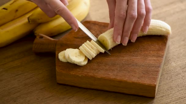女厨师的手把香蕉切成薄片 香蕉环 烹调健康的素食食物或零食 — 图库视频影像