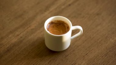 Tahta masada bir fincan espresso kahvesi. Bir fincan dumanı üstünde kahve.