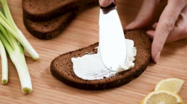 Çavdar ekmeğine krem peynir serpme görüntüsü. Yemek hazırlıyorum.