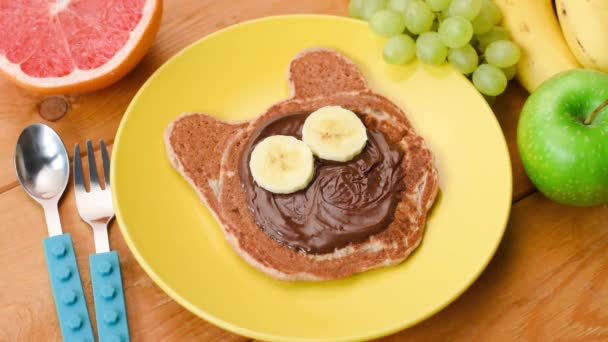 停止为孩子准备早餐的运动 用巧克力和水果做成的具有滑稽面孔的猫形薄饼 — 图库视频影像