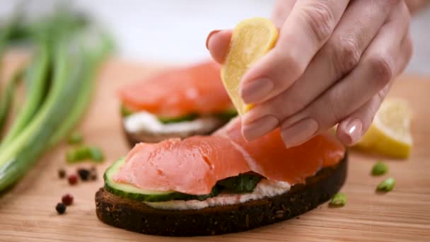 Vrouwelijke Chef Knijpt Citroen Sandwich Met Gerookte Zalm Close Uitzicht — Stockvideo